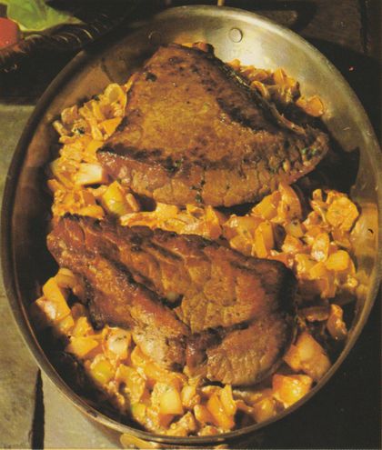 Gebratene Beefsteaks mit Zwiebelsoße auf einem Bett aus Spätzle, angerichtet auf einem ovalen Teller. Die Steaks sind braun gebraten und mit Kräutern gewürzt, die Spätzle mit goldbraunen Zwiebelstückchen vermischt.